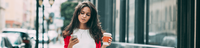 Kobieta idaca z telefonem i kawa