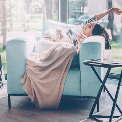 Kobieta w fotelu pod kocem